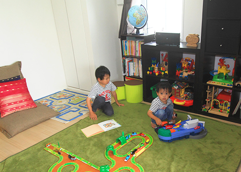 リビング隣の居室で伸び伸び遊ぶお子様たち。おもちゃはグリッド式の棚に整然と収納されている。