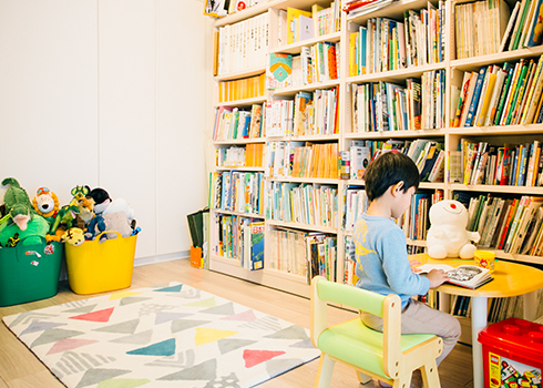 プレイルームの壁面全体を覆う本棚は児童書や百科事典などの本で満たされ、いつでも知識に触れられる環境に。